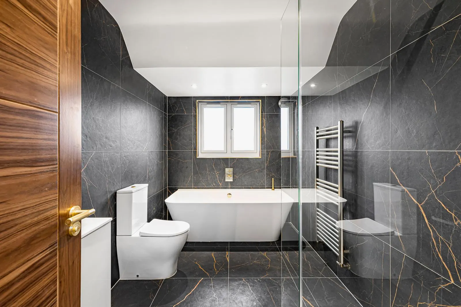 Marble bathroom with brass shower fittings, Hertfordshire